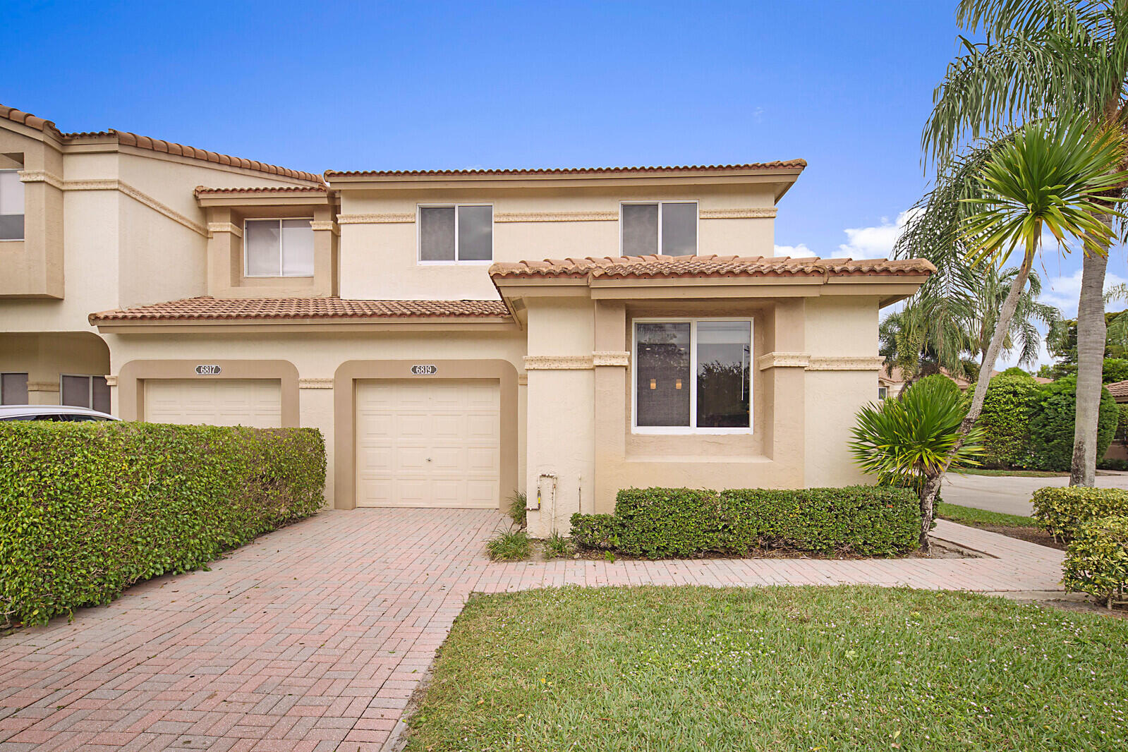 6819 Via Regina Boca Raton, FL 33433 - Photo 3 of 39 a front view of a house with a yard and garage