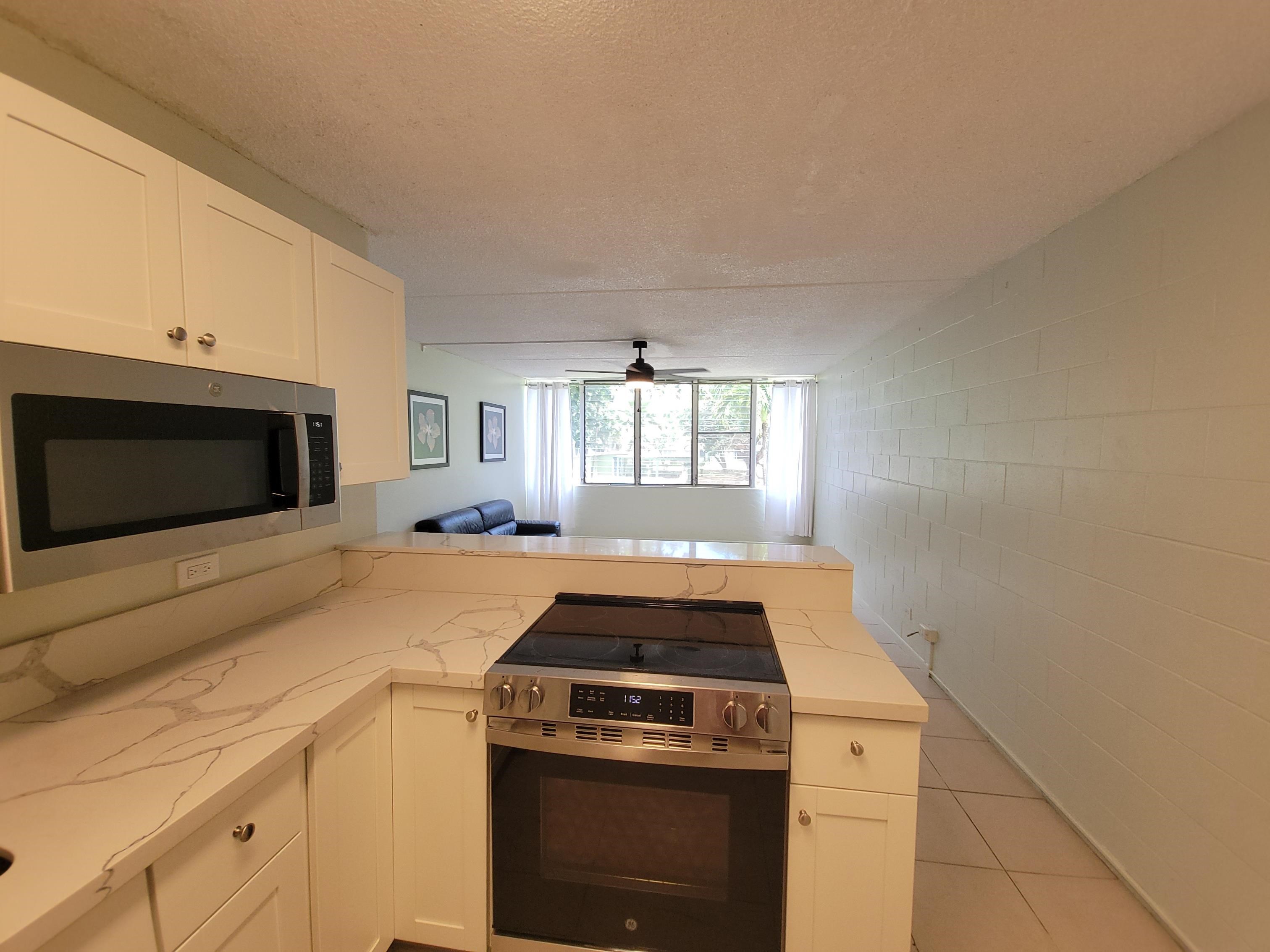 111 Kahului Beach Road, Unit B213 Kahului, HI 96732 - Photo 2 of 28 a kitchen with a stove and a microwave