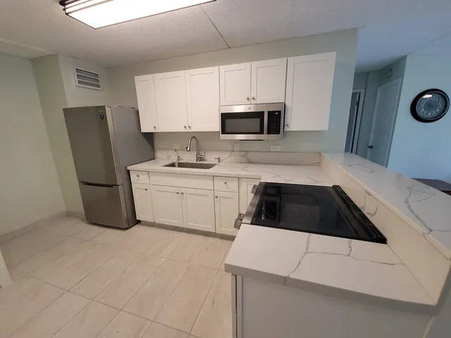 a kitchen with a sink a stove and cabinets