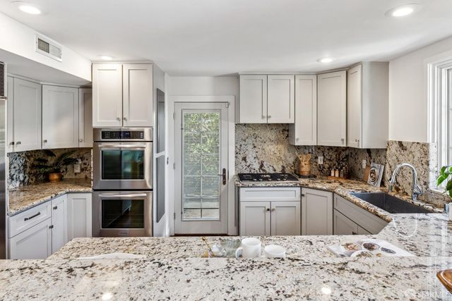 a bathroom with a granite countertop sink and bathtub