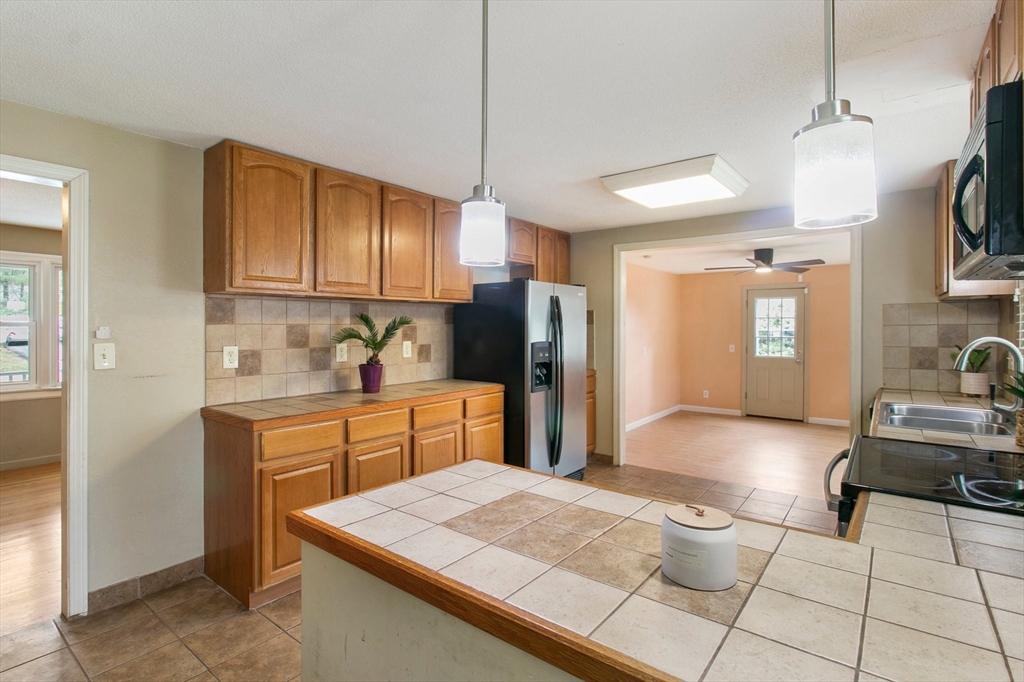 494 Tiffany Street Springfield, MA 01108 - Photo 11 of 40 a kitchen with stainless steel appliances granite countertop a sink refrigerator and cabinets