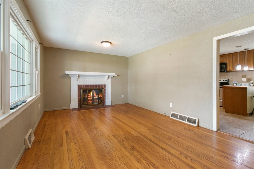 494 Tiffany Street Springfield, MA 01108 - Photo 14 of 40 a view of an empty room with a fireplace and a window