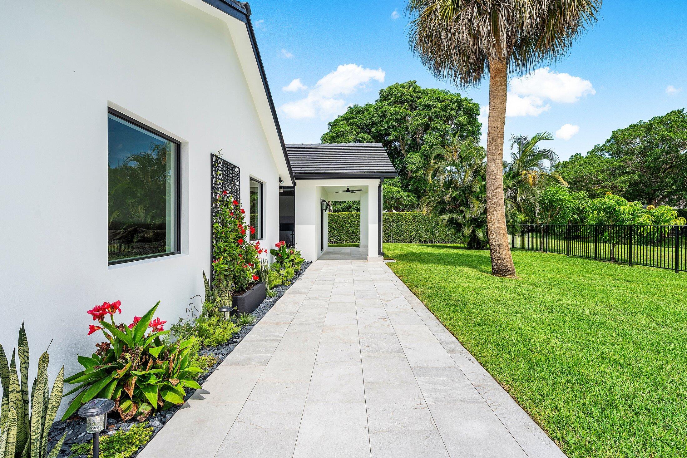 6901 Giralda Circle Boca Raton, FL 33433 - Photo 68 of 83 a front view of a house with a yard and potted plants