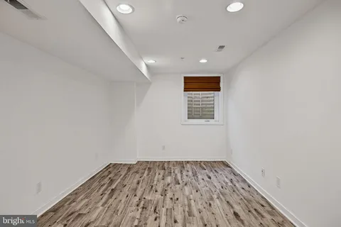 a view of a room with wooden floor and white walls