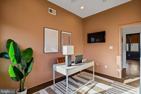 a living room with furniture a flat screen tv and a potted plant