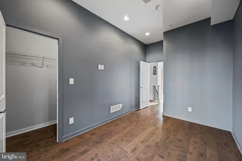 a view of an empty room with wooden floor
