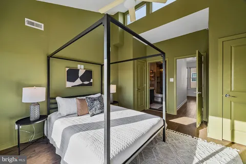 a bedroom with a bed and a painting on the wall