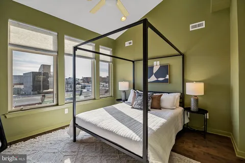 a bedroom with a bed and a large window