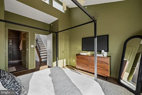 a bedroom with a bed and a flat tv screen on dresser