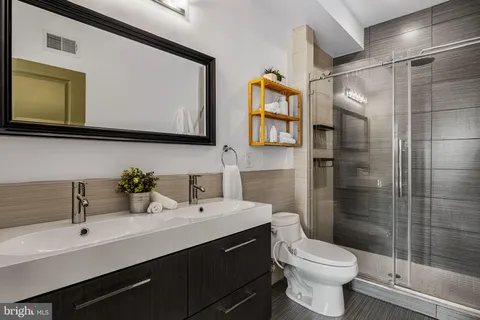 a bathroom with a sink toilet a mirror and shower