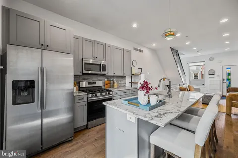 a kitchen with kitchen island a refrigerator stove microwave and cabinets