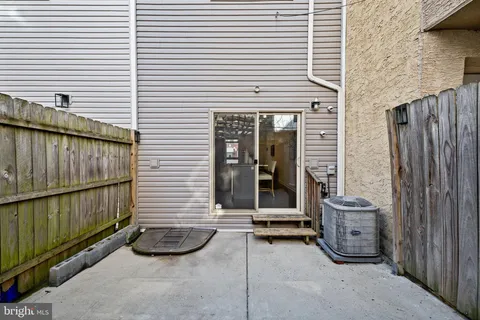 a view of a patio with table and chairs and wooden fence