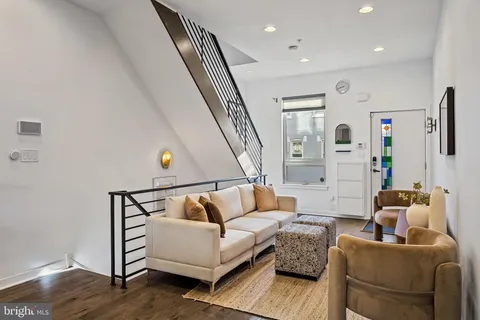 a living room with furniture and stairs