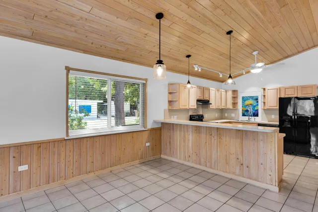 a kitchen with stainless steel appliances kitchen island granite countertop a refrigerator oven a sink a stove and island