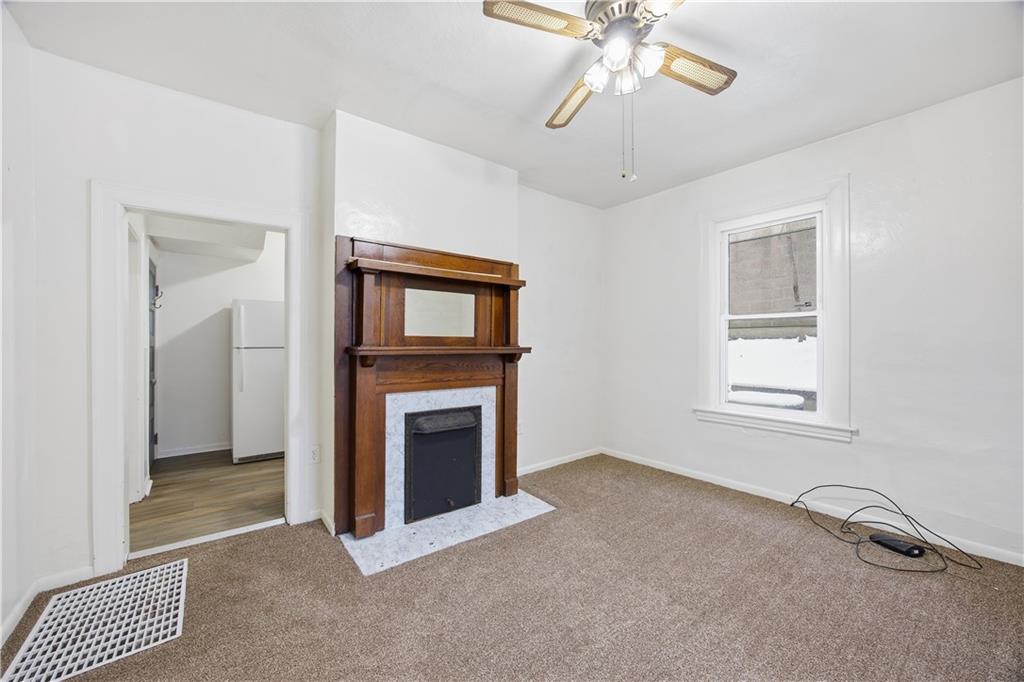 a view of an empty room with a fireplace and a window