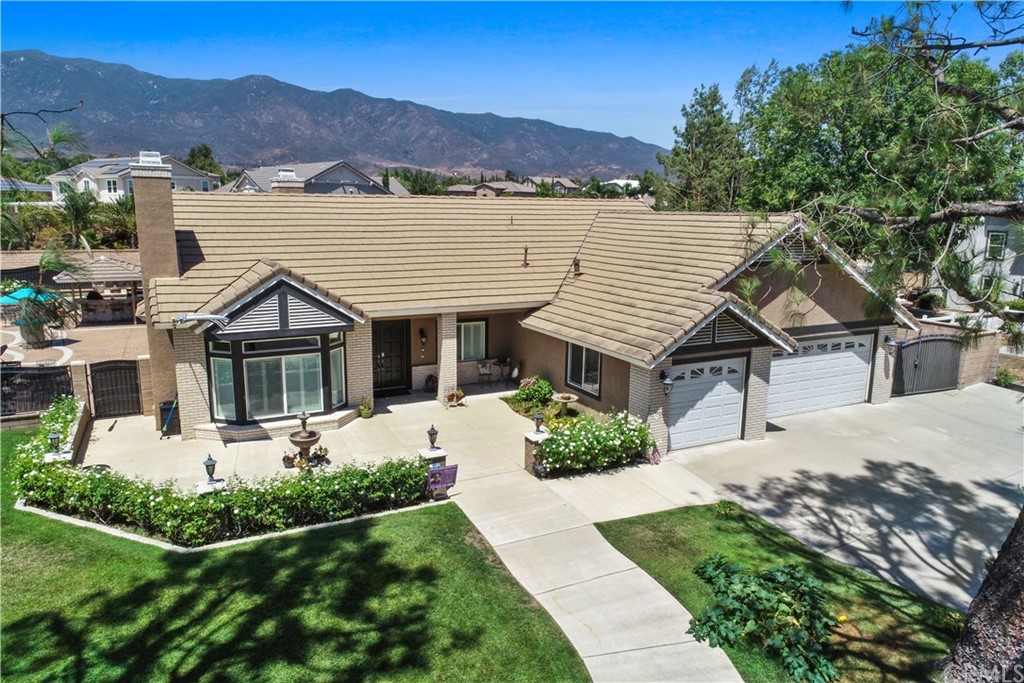 13170 Arapaho Road Rancho Cucamonga, CA 91739 - Photo 1 of 1 a front view of a house with a garden and mountain view
