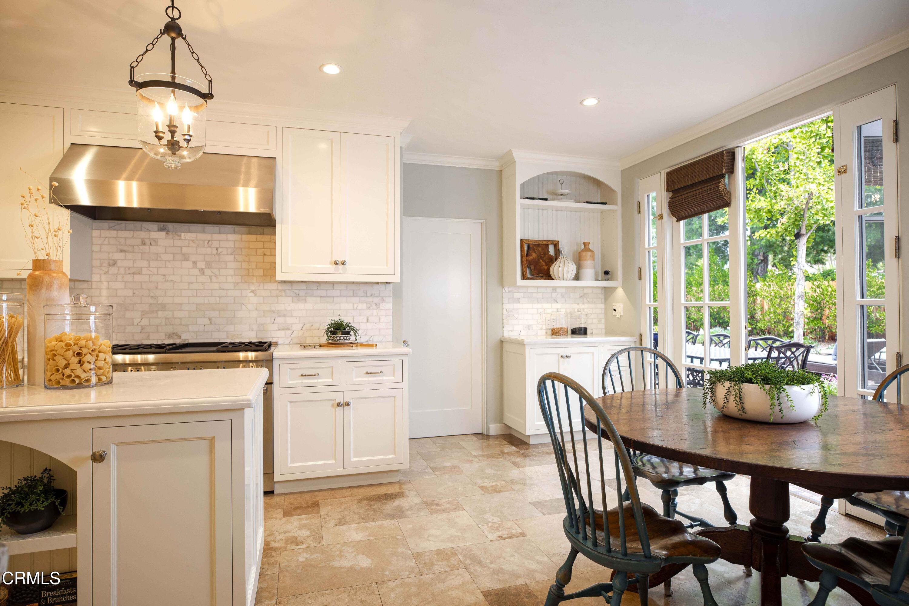 Undisclosed Address Pasadena, CA 91106 - Photo 12 of 40 a kitchen with stainless steel appliances granite countertop a stove a refrigerator a kitchen island a dining table and chairs with wooden floor