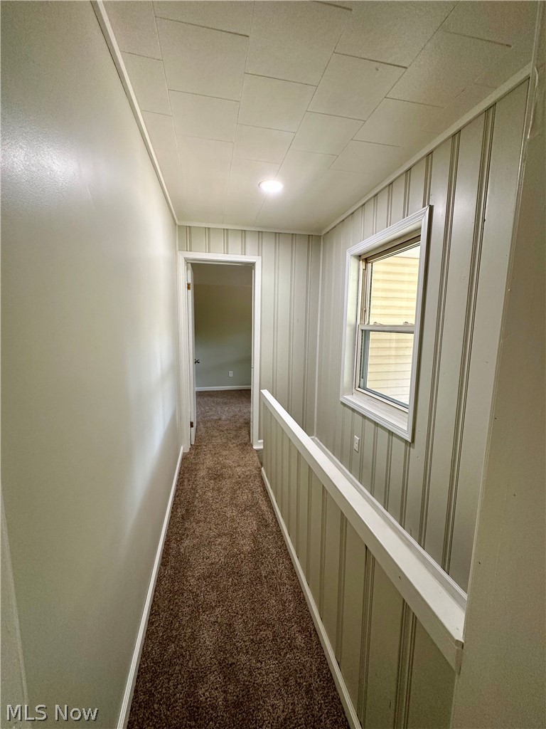 48963 Bloomfield Road East Liverpool, OH 43920 - Photo 18 of 25 Hallway with wood walls and dark colored carpet