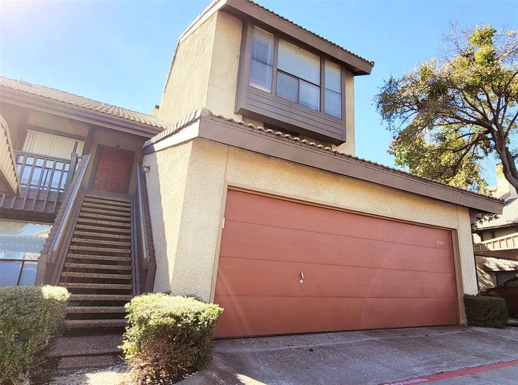 a view of a house with a large windows and flower plants