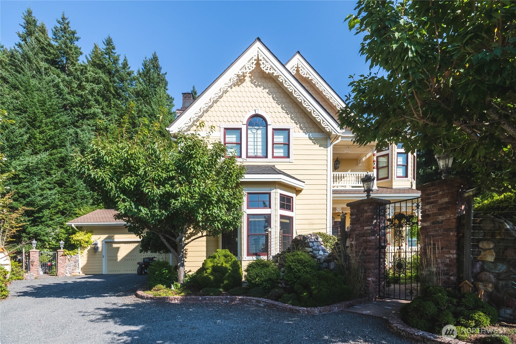 a view of a white house next to a road and trees