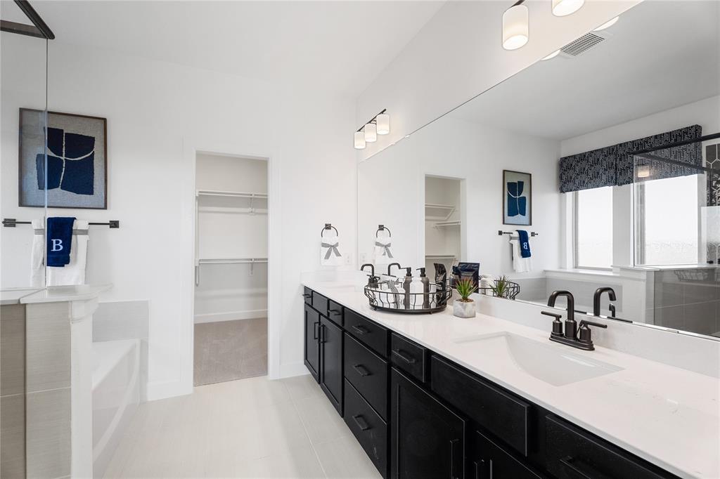 813 Anthem Lane Forney, TX 75126 - Photo 11 of 21 a spacious bathroom with a double vanity sink a mirror and a bathtub