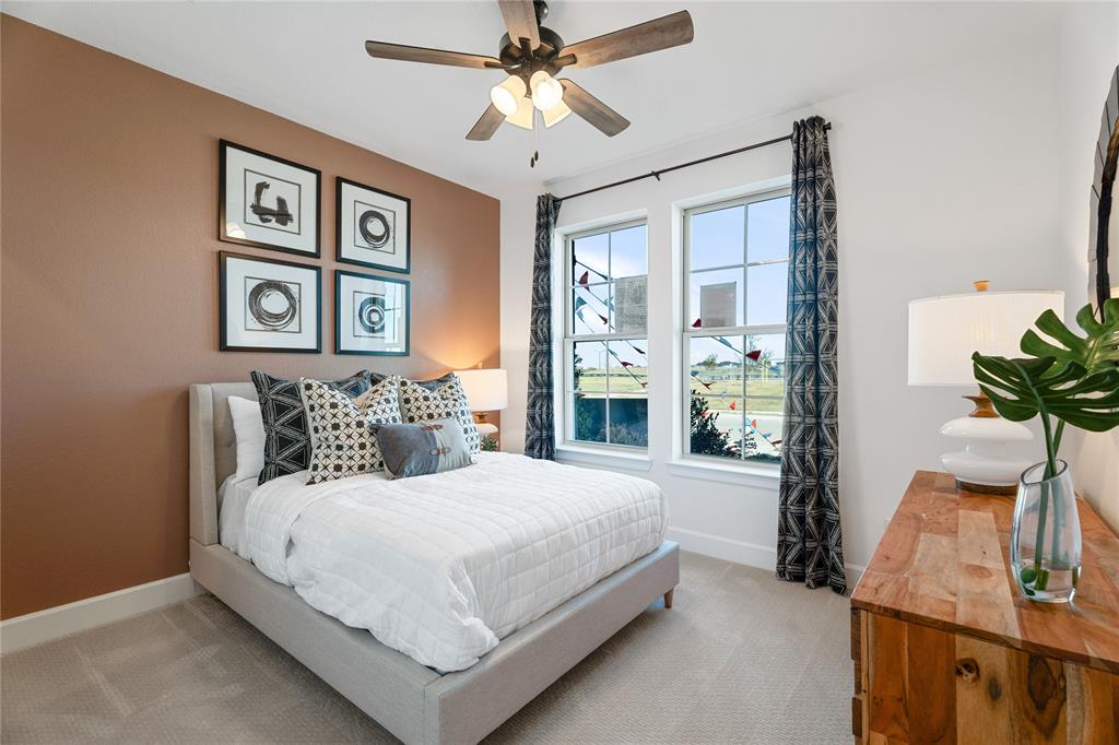 813 Anthem Lane Forney, TX 75126 - Photo 15 of 21 a bedroom with a large bed and a chandelier