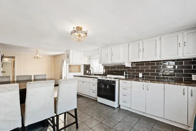 a kitchen with stainless steel appliances a white table chairs and a refrigerator