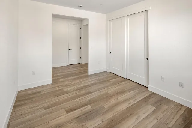 a view of an empty room with wooden floor