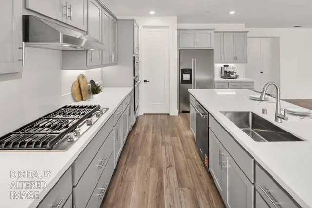 a kitchen with kitchen island a sink stove and refrigerator