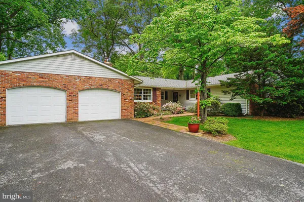 a view of a house with a yard and a large tree