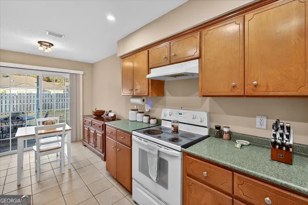 a kitchen with stainless steel appliances granite countertop a refrigerator sink and stove