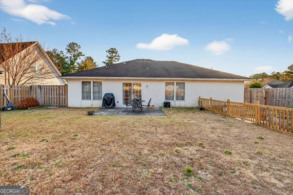 a backyard of a house with table and chairs