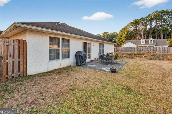 a view of a house with backyard and sitting area