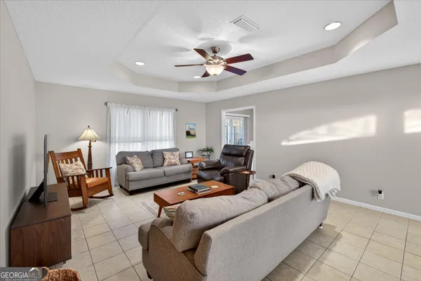 a dining room with furniture a chandelier and wooden floor