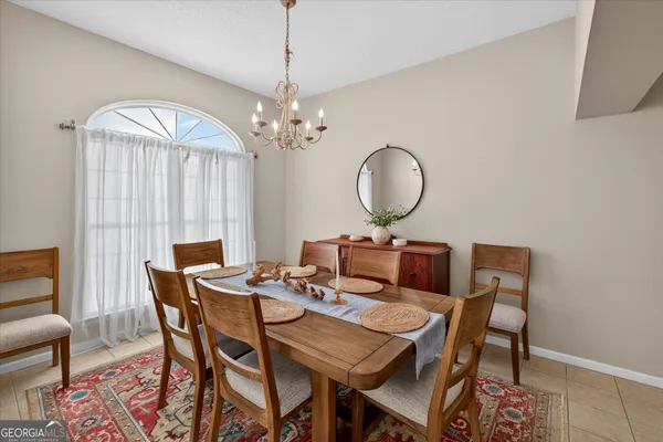 a view of a dining room with furniture and a chandelier
