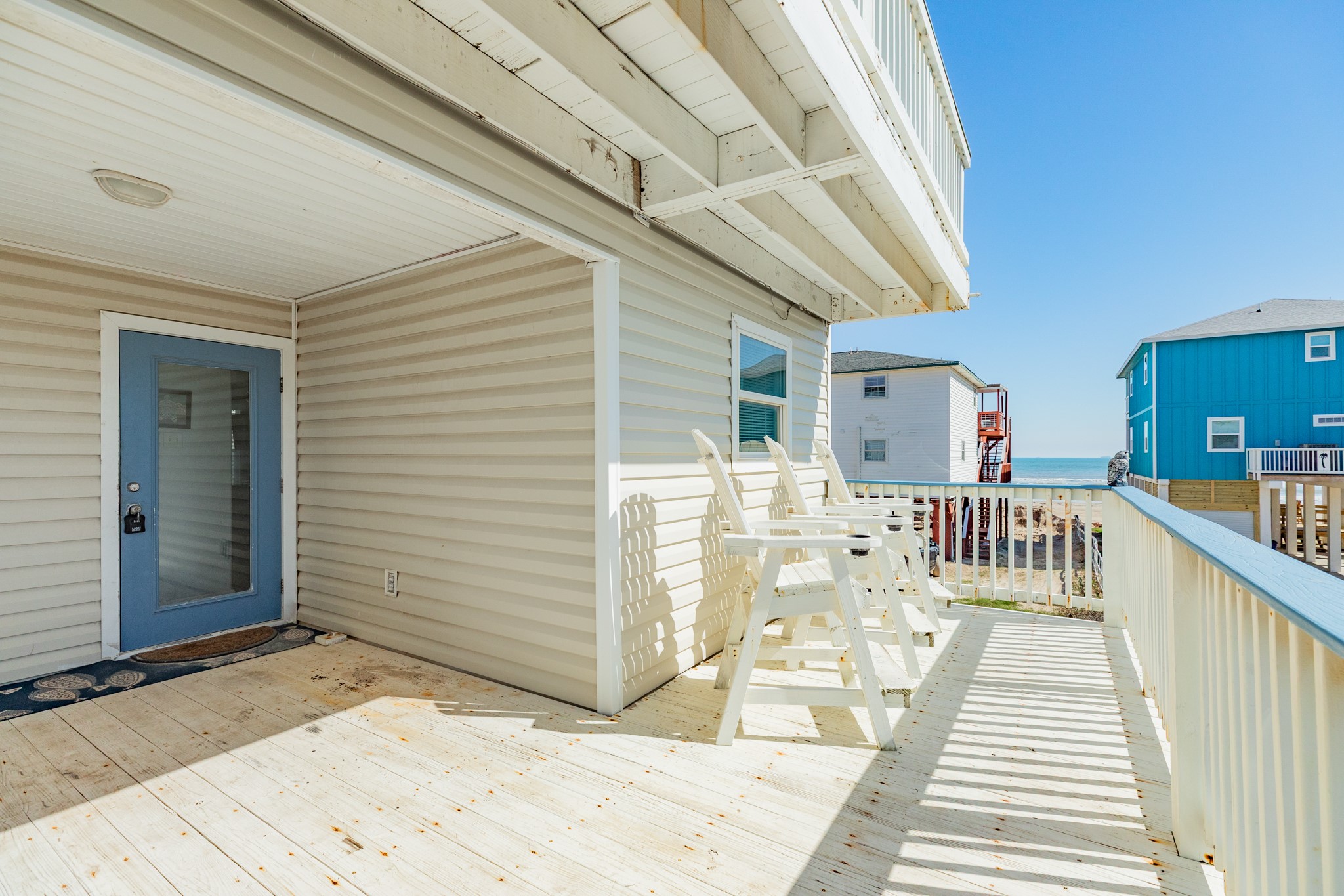 107 Howard Avenue Surfside Beach, TX 77541 - Photo 13 of 38 Spacious deck with Adirondack chairs, perfect for morning coffee or evening relaxation with water views nearby.