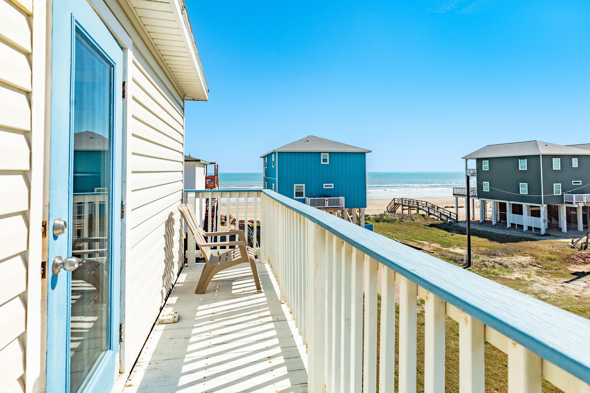 107 Howard Avenue Surfside Beach, TX 77541 - Photo 15 of 38 Private outdoor space with railing-lined deck and direct sightlines toward the beach access and surrounding coastal homes.