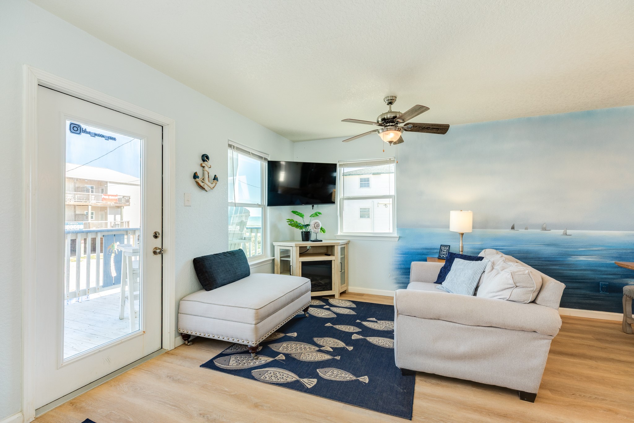 107 Howard Avenue Surfside Beach, TX 77541 - Photo 21 of 38 Inviting seating arrangement with ceiling fan, abundant natural light, and beach-themed accents that create a relaxed coastal atmosphere.
