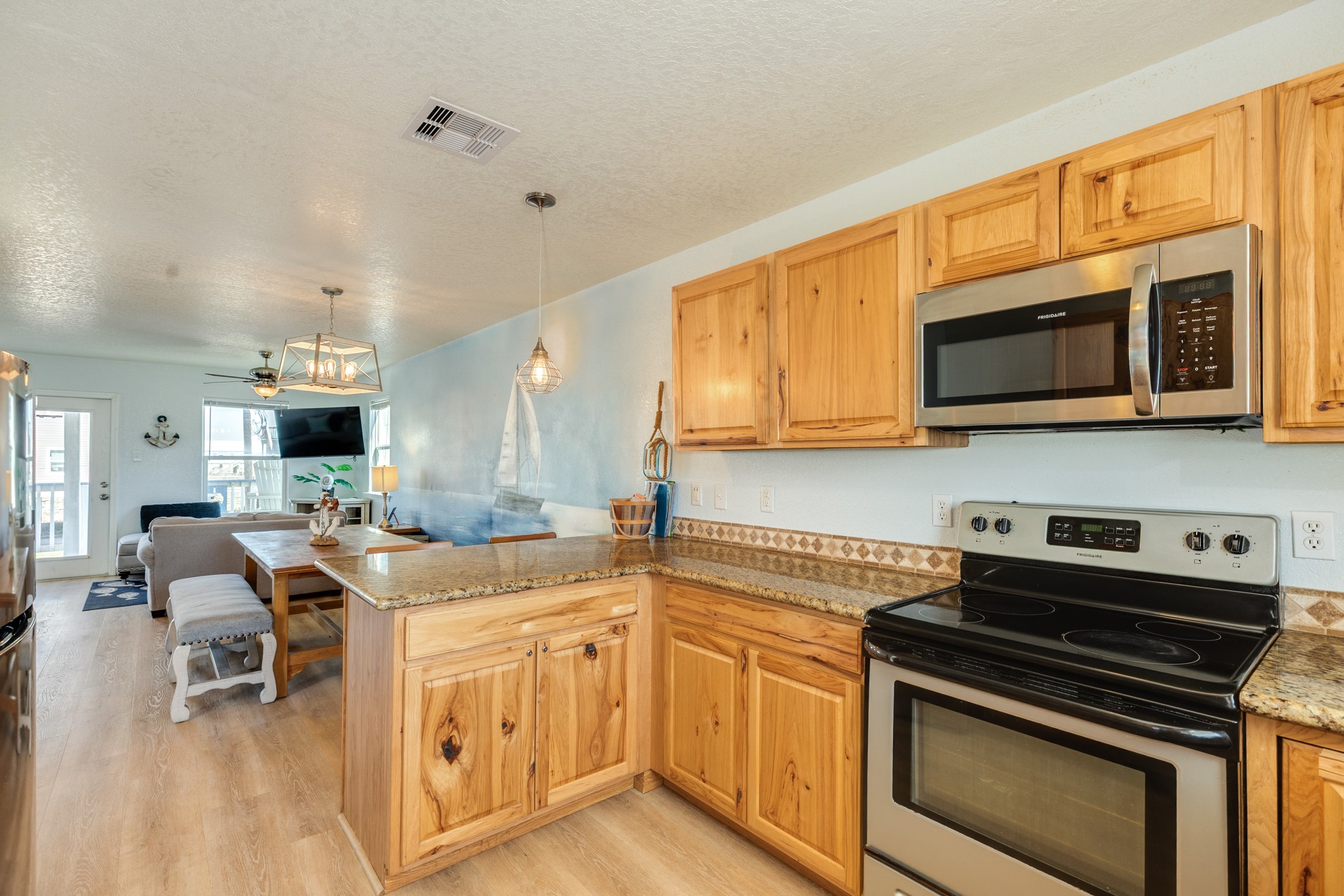 107 Howard Avenue Surfside Beach, TX 77541 - Photo 24 of 38 Open kitchen layout with wraparound countertops and bar seating, seamlessly connected to the main living areas.