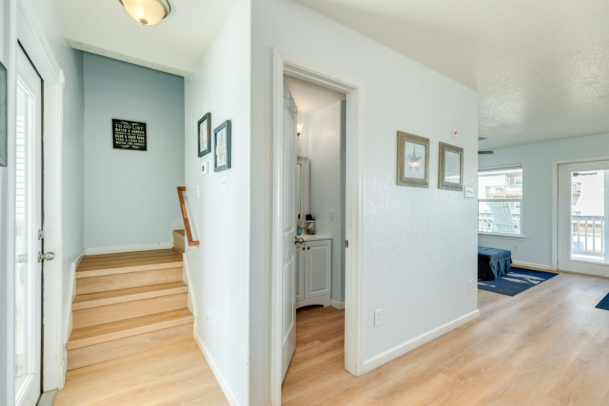 107 Howard Avenue Surfside Beach, TX 77541 - Photo 26 of 38 Central hallway providing access to the staircase and main living areas, offering a practical and well-designed layout.