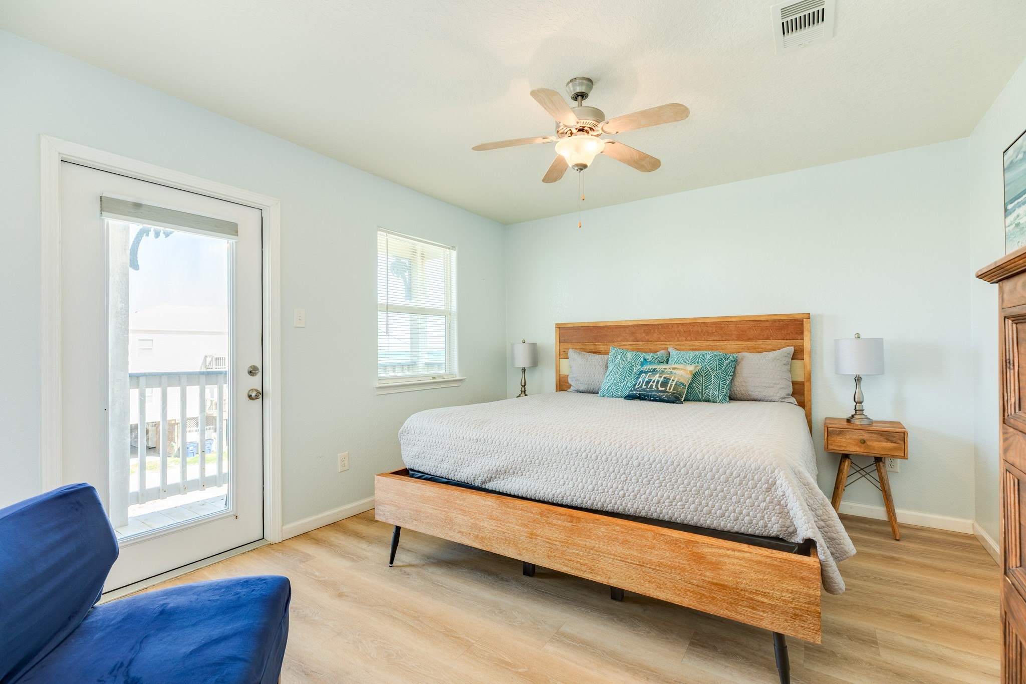 107 Howard Avenue Surfside Beach, TX 77541 - Photo 27 of 38 Spacious and serene primary suite featuring a wood bed frame, soft coastal tones, and direct access to a private balcony for enjoying fresh sea breezes.