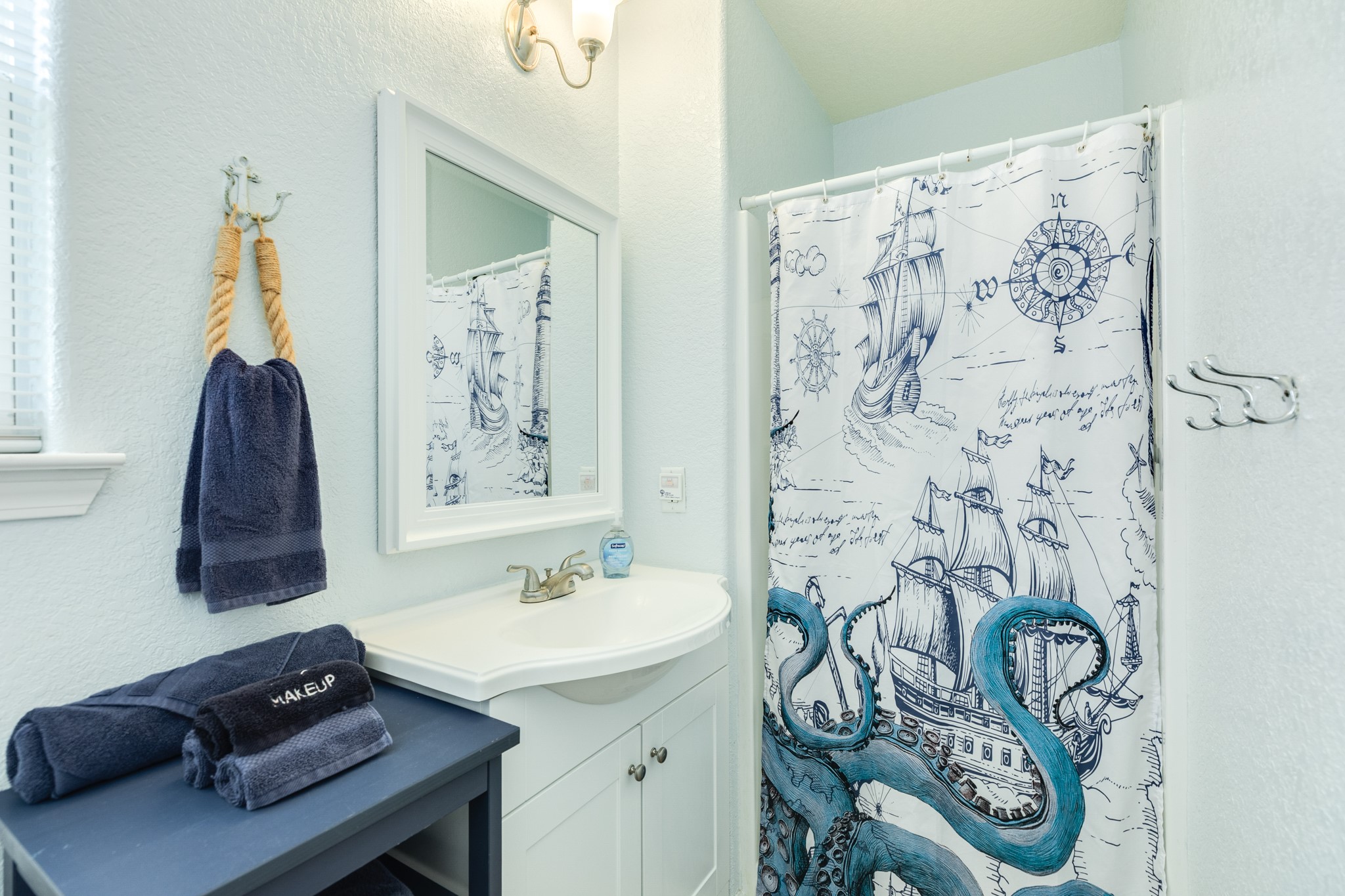 107 Howard Avenue Surfside Beach, TX 77541 - Photo 29 of 38 Bright en-suite bath with vanity storage, updated fixtures, and a coastal-inspired shower/tub combination.