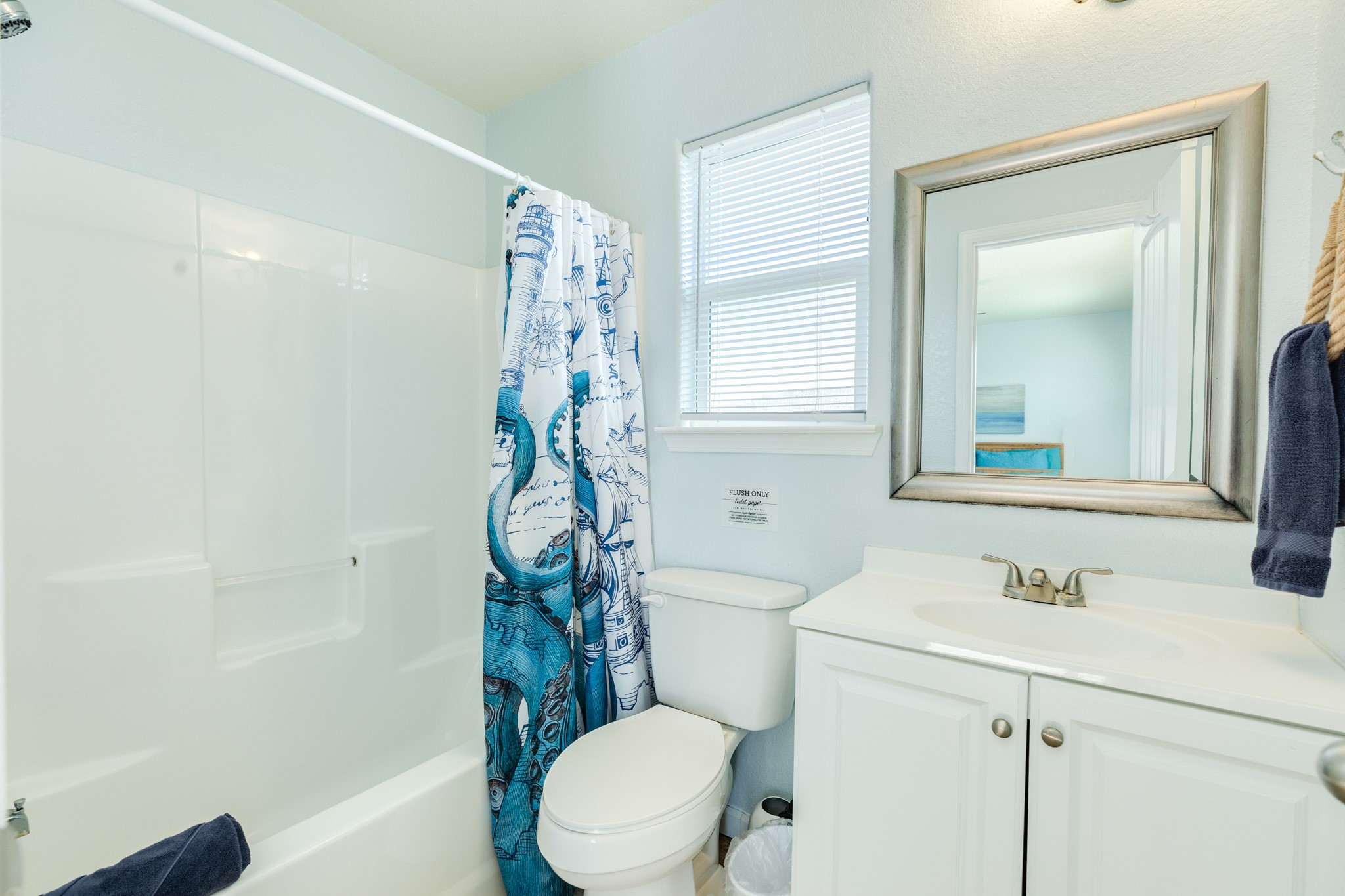107 Howard Avenue Surfside Beach, TX 77541 - Photo 32 of 38 Well-appointed full bath featuring a clean white vanity, shower/tub combo, and natural light from the window.