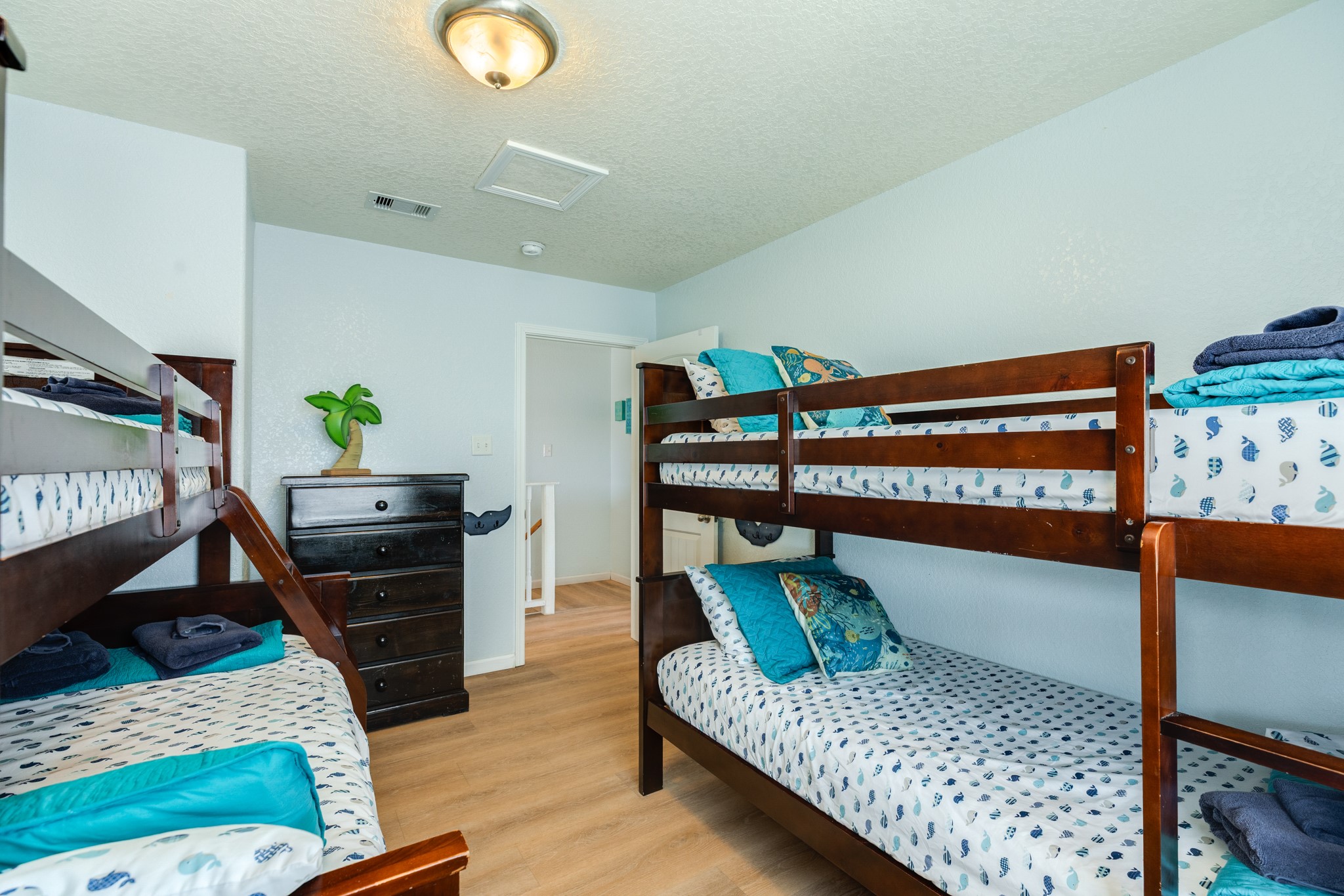 107 Howard Avenue Surfside Beach, TX 77541 - Photo 34 of 38 Spacious layout with sturdy wood bunks and playful coastal mural, creating a welcoming space for additional guests.