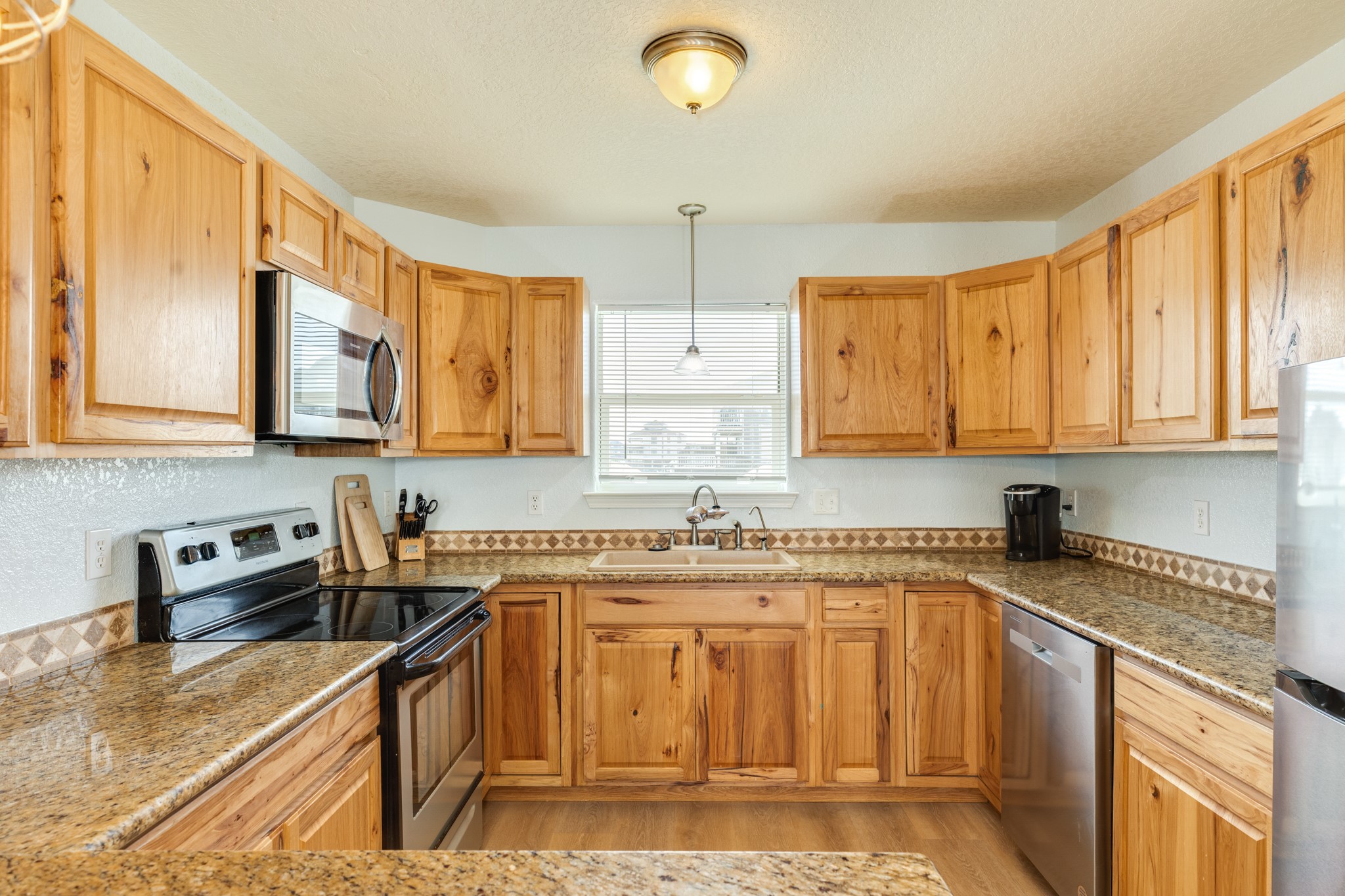 107 Howard Avenue Surfside Beach, TX 77541 - Photo 6 of 38 Well-appointed kitchen featuring stainless steel appliances, generous counter space, and ample cabinetry for storage.