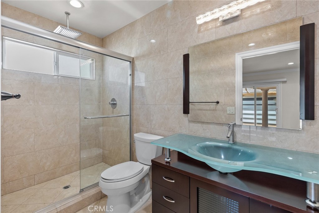 931 University Avenue Burbank, CA 91504 - Photo 39 of 49 a bathroom with a granite countertop sink a toilet and shower