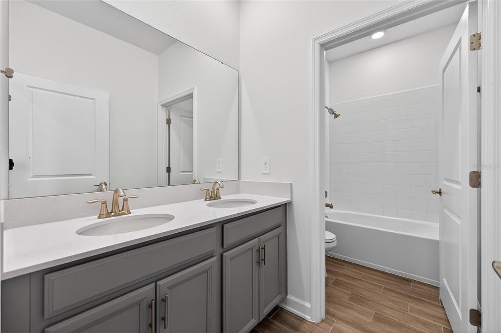 11128 Lore Way Orlando, FL 32832 - Photo 14 of 79 a bathroom with a tub sink double vanity and mirror