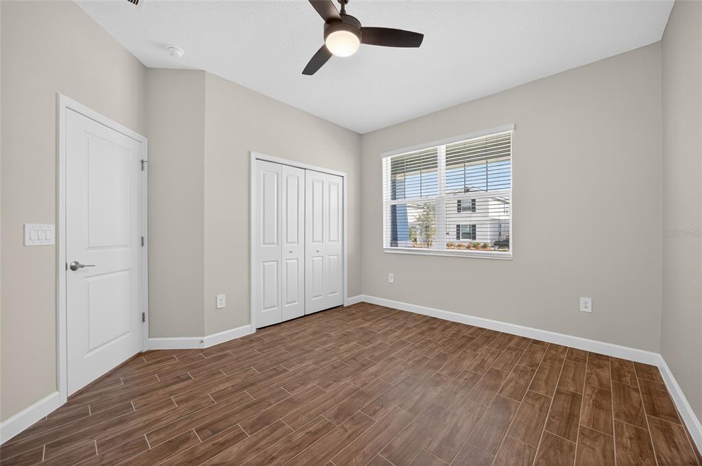 11128 Lore Way Orlando, FL 32832 - Photo 16 of 79 a view of an empty room with wooden floor and a window