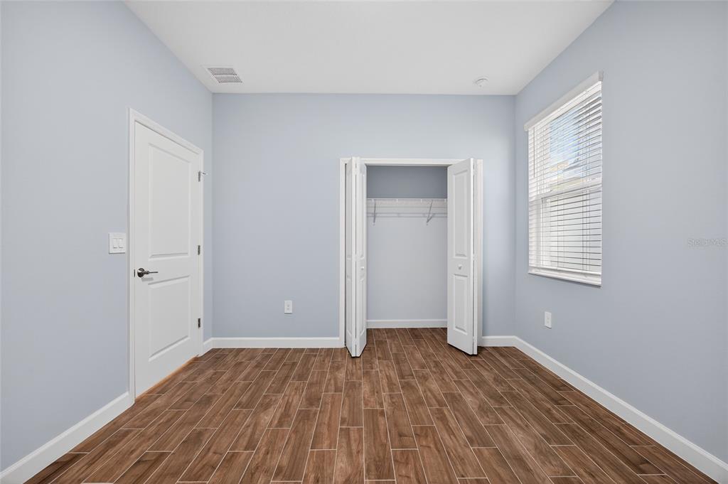 11128 Lore Way Orlando, FL 32832 - Photo 18 of 79 an empty room with wooden floor and windows