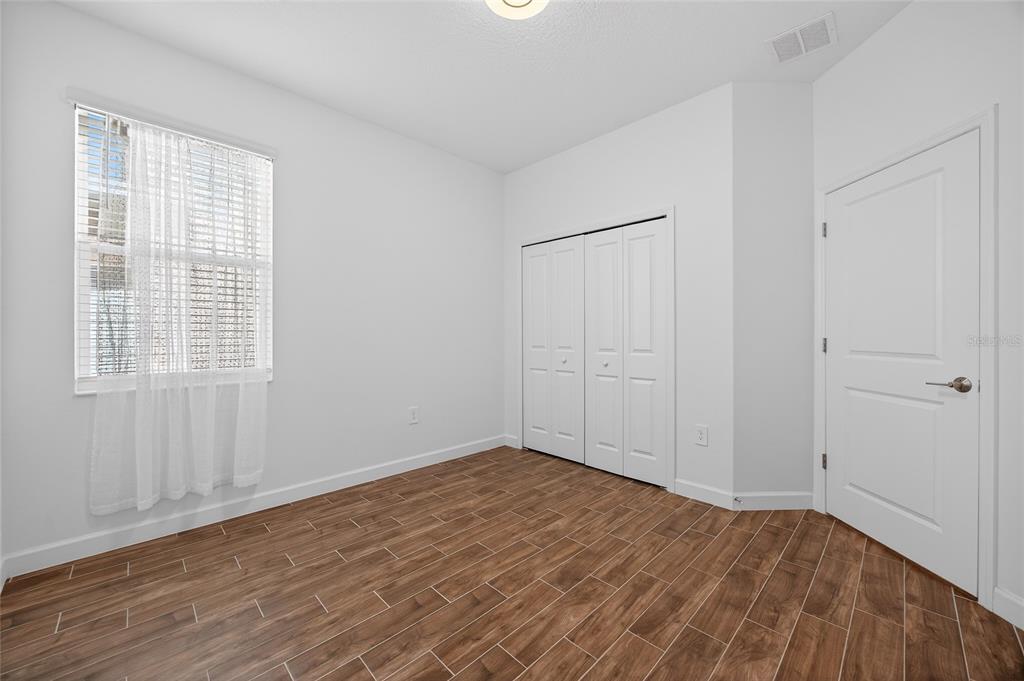 11128 Lore Way Orlando, FL 32832 - Photo 24 of 79 a view of an empty room with wooden floor and a window
